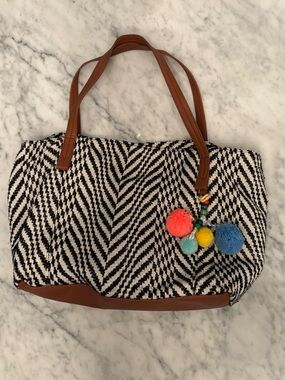 Black and white fabric purse with pompom tassels and lots of room and pockets